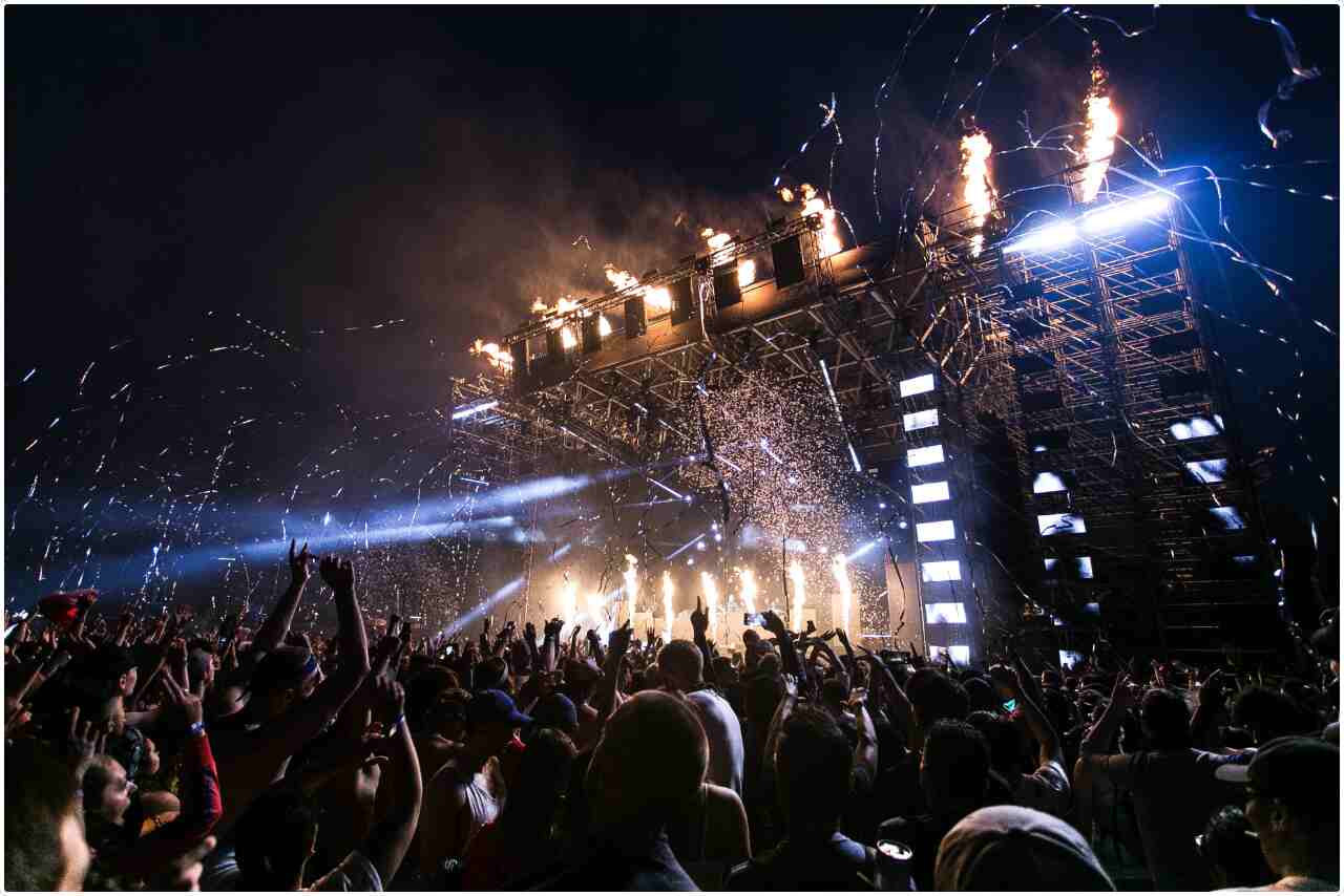 Crowd of people enjoying a live concert under bright stage lights